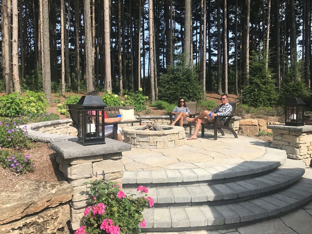 Patio with fire pit and chairs.